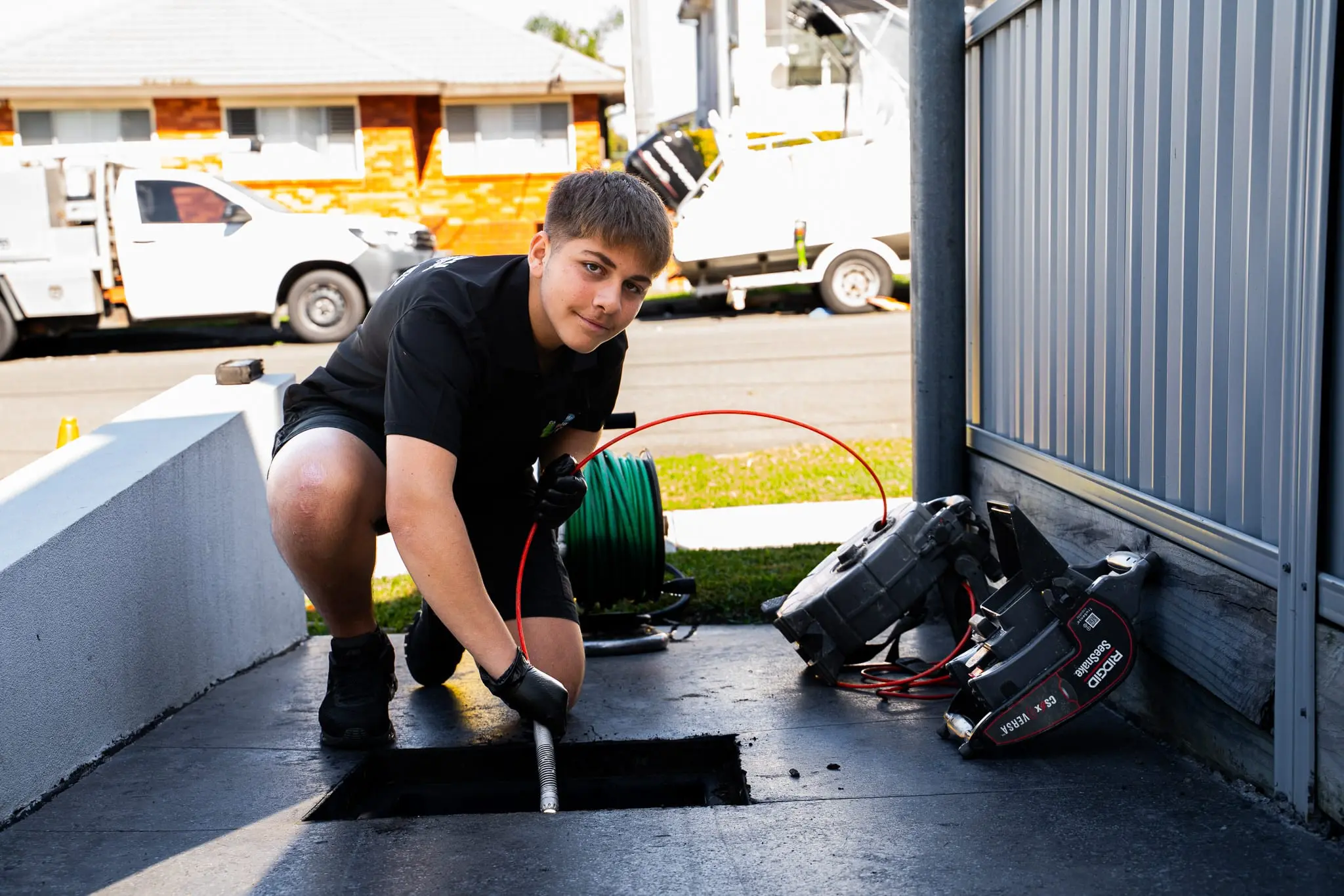 Mr Flow plumber feeding a CCTV drain camera into an outdoor drain