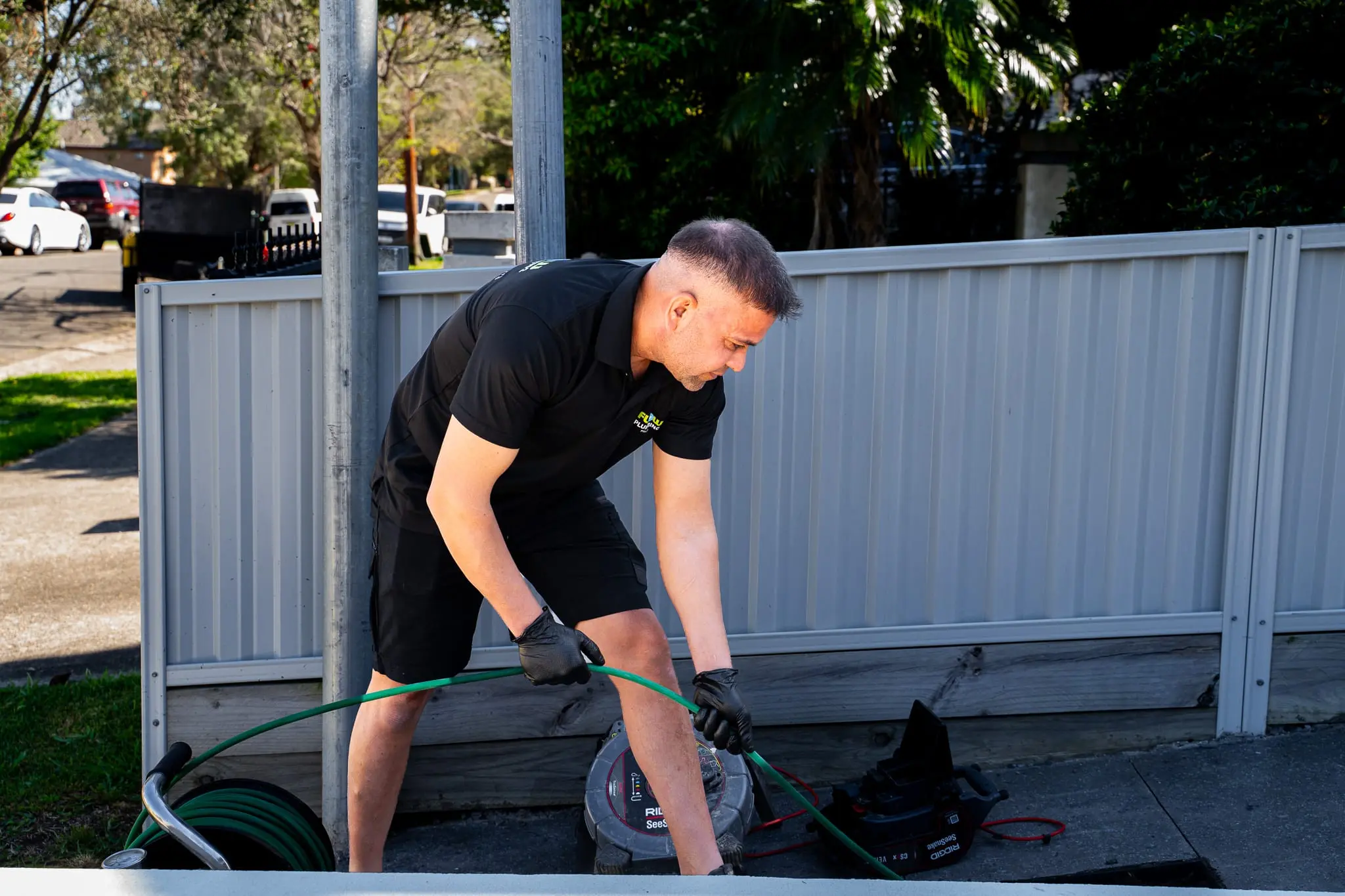 Mr Flow plumber feeding a high-pressure jetter hose into a blocked drain
