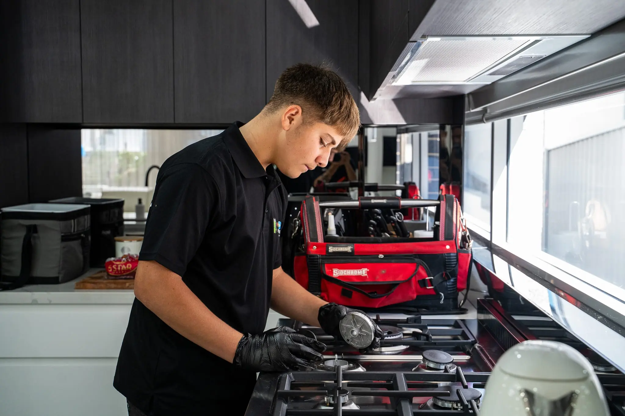 Mr Flow plumber checking the burners on a gas cooktop