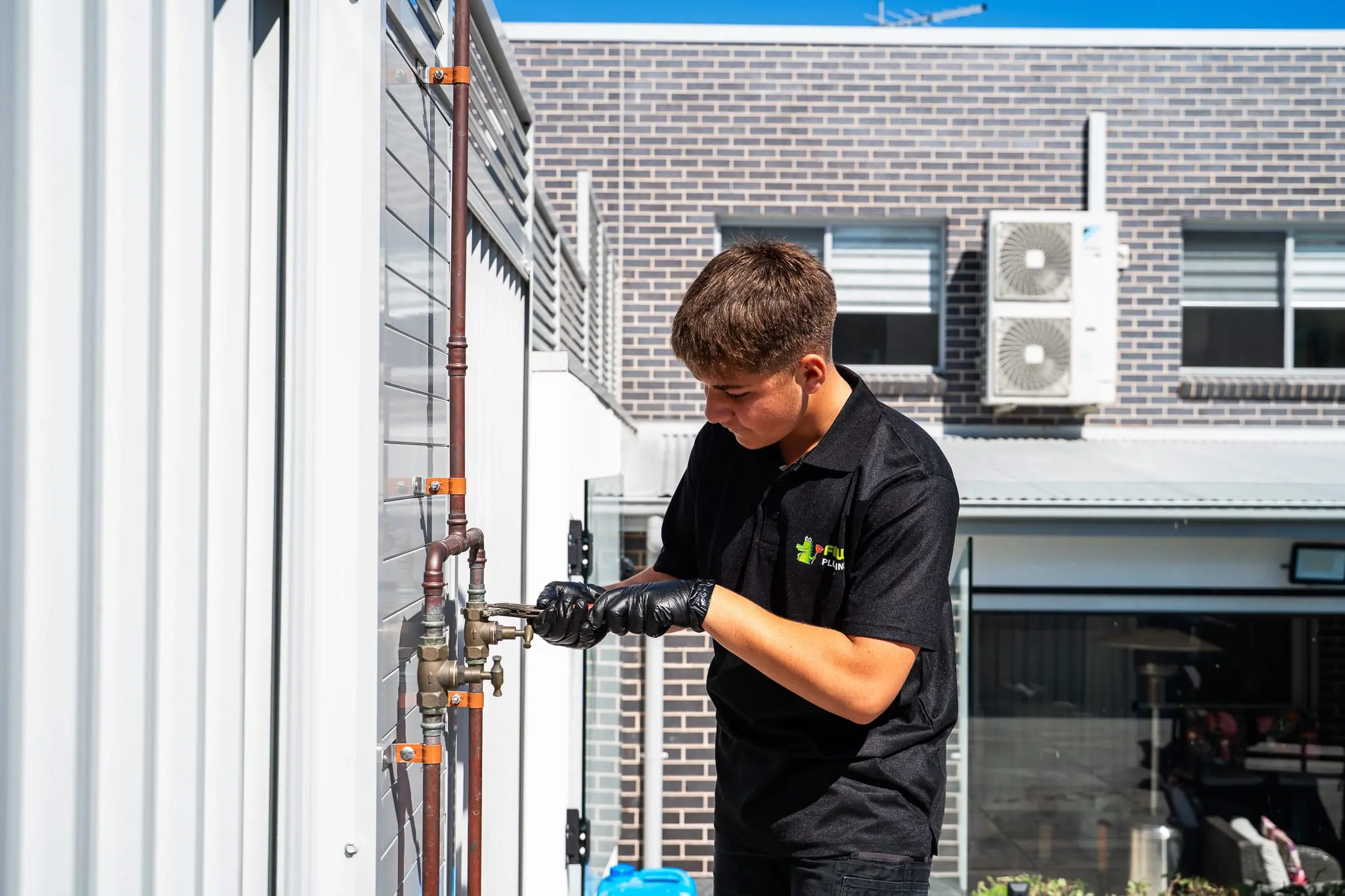 Mr Flow plumber tightening a valve on external copper pipework