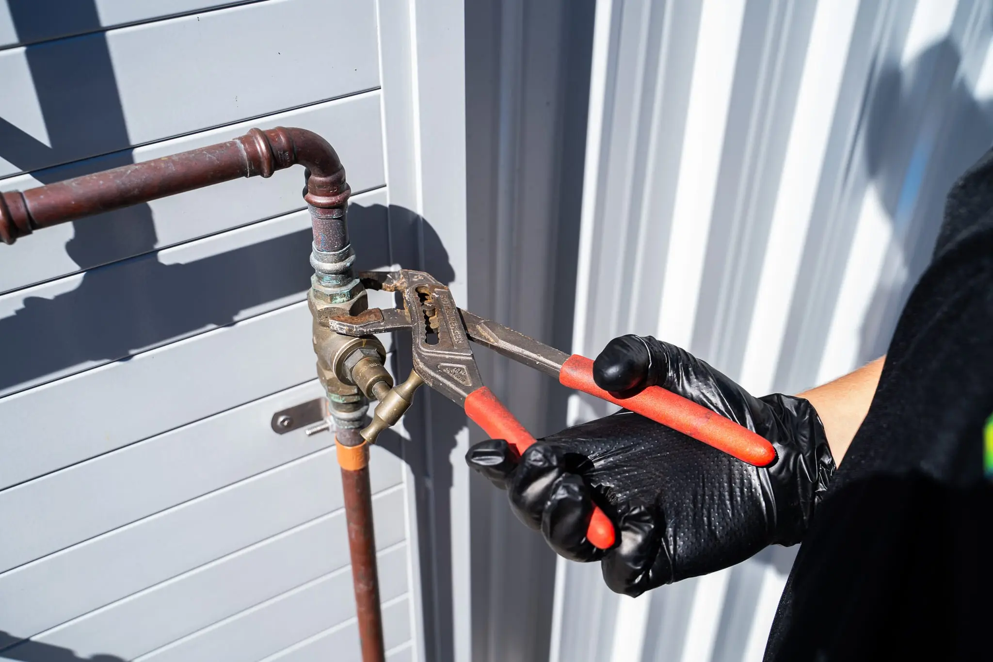 Close-up of pipe grips on a brass fitting on copper water pipe