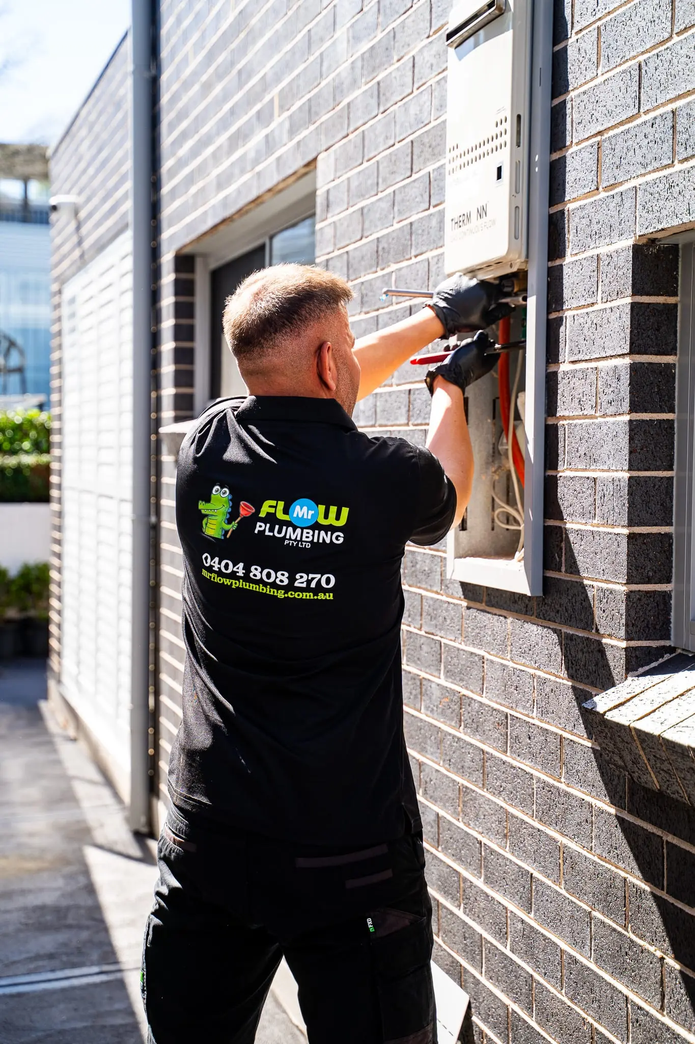 Mr Flow plumber working on a continuous-flow hot water system