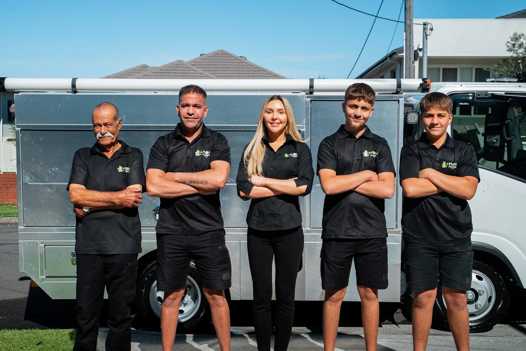 The Mr Flow Plumbing crew, arms crossed, in front of their fully-stocked service truck