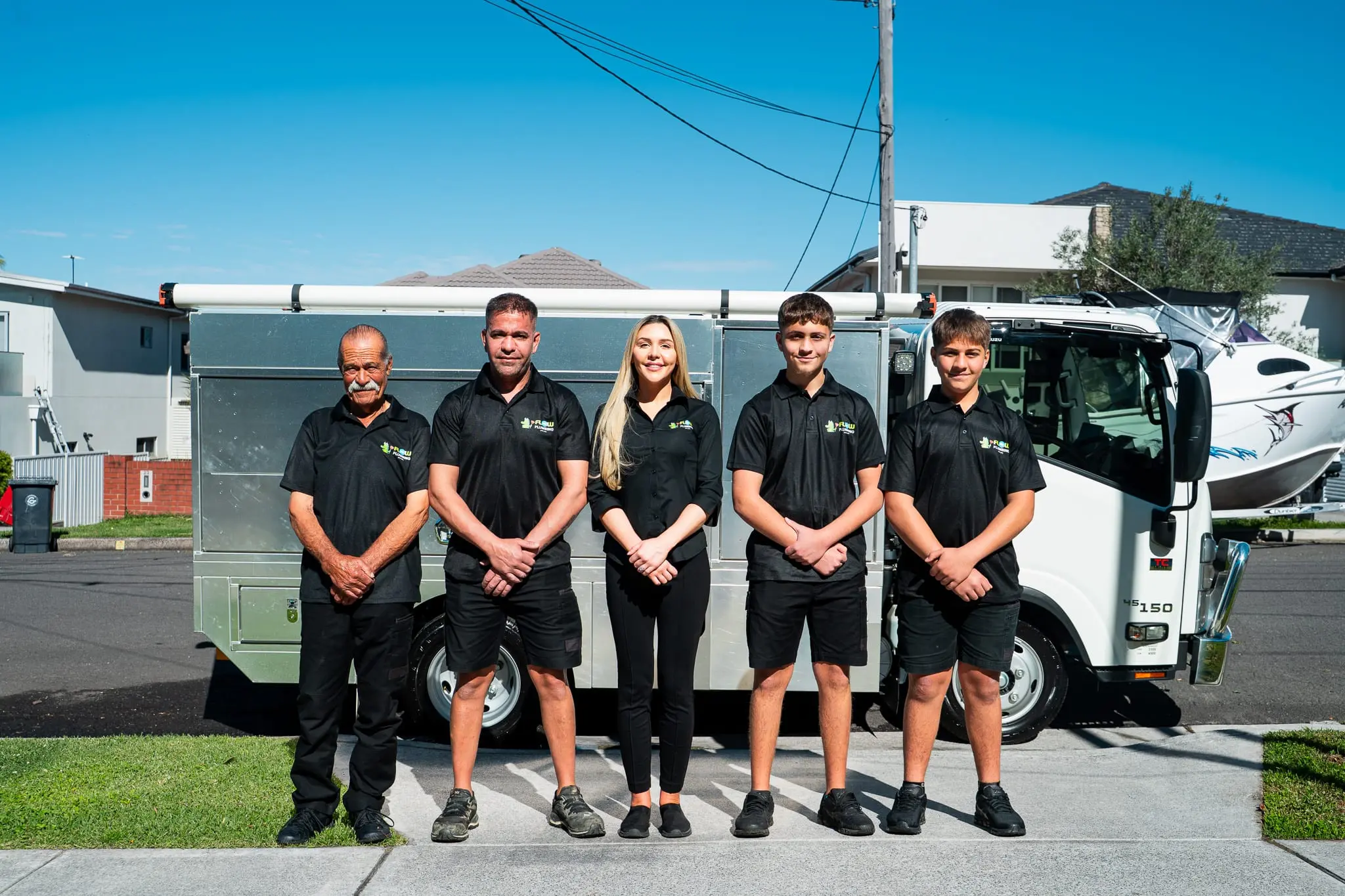 The Mr Flow Plumbing team lined up in front of their service truck on a Sydney street