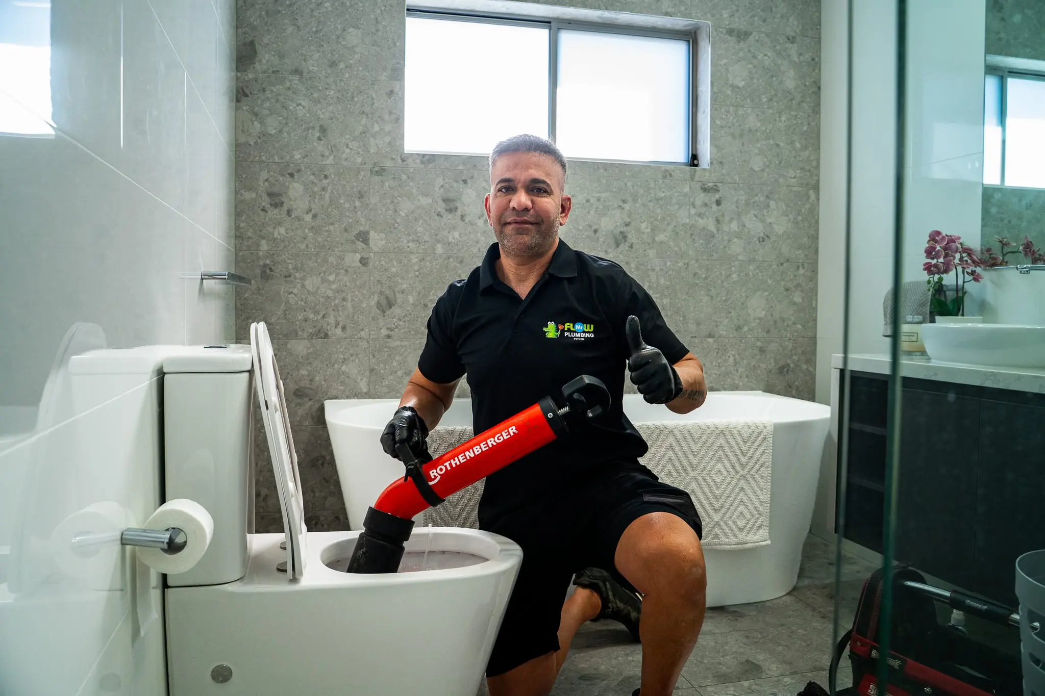 Smiling Mr Flow plumber giving a thumbs up after clearing a blocked toilet